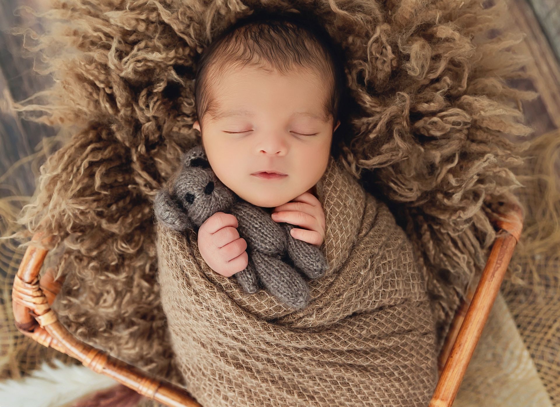 Newborn lying in a
basket with soft lighting in Cary, NC photography studio