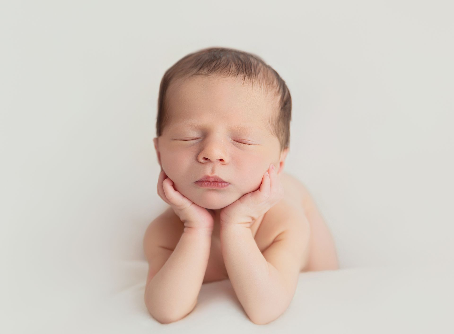 Timeless newborn on frog pose
portrait with soft natural light in Cary, NC studio