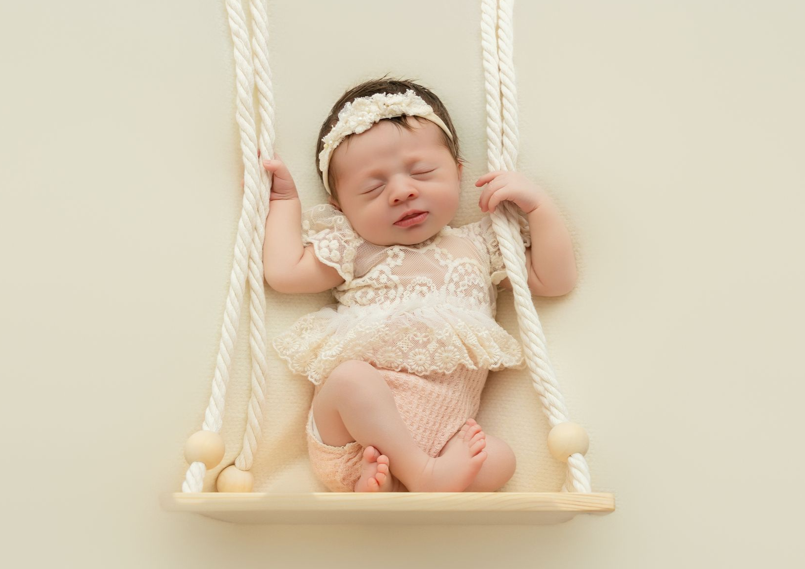 Peaceful newborn twins sleeping on soft neutral blankets in a bright studio
