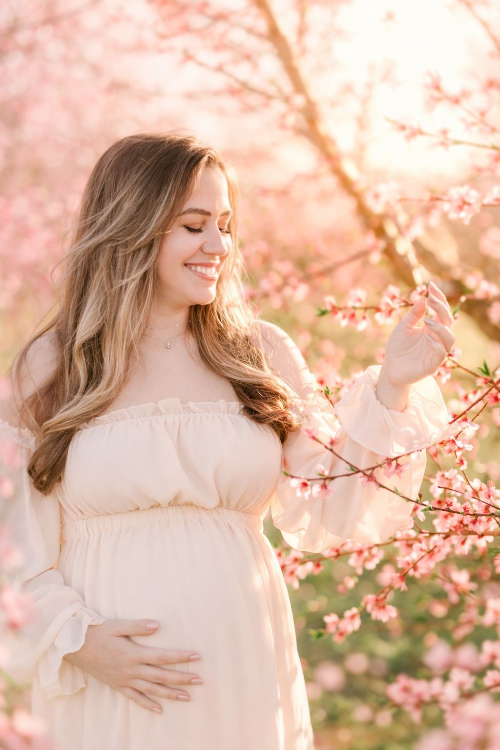 Mother and Daughter smiling at the peach blossoms blooms
