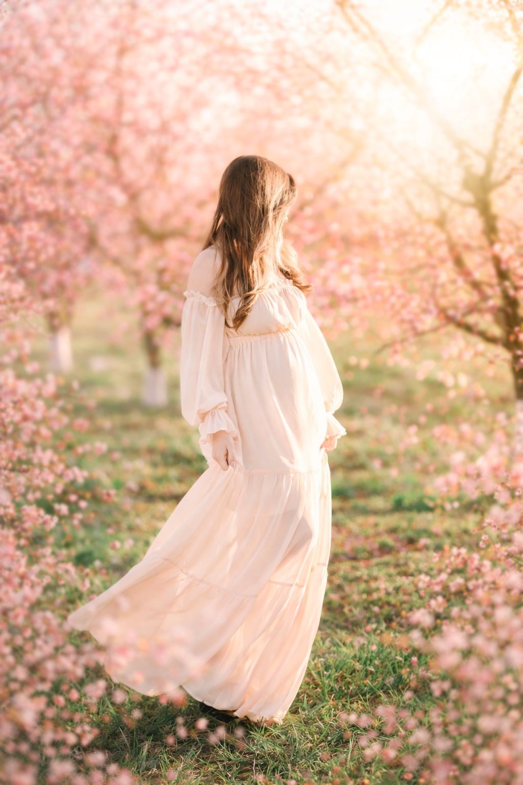 Pregnant mother walking through peach blossom trees during spring maternity photos in Raleigh NC