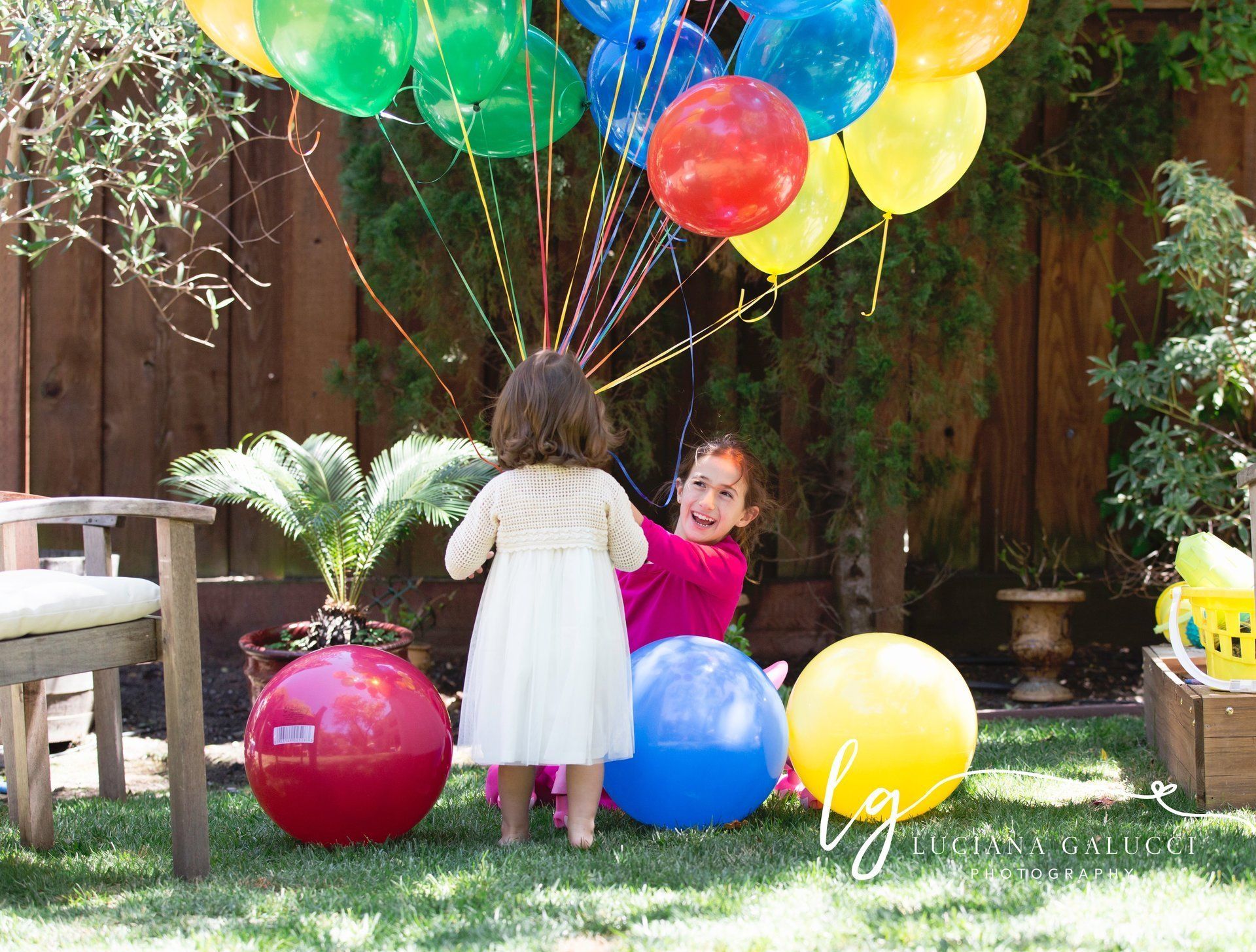 Sisters enjoying a birthday party with colorful balloons in Raleigh NC