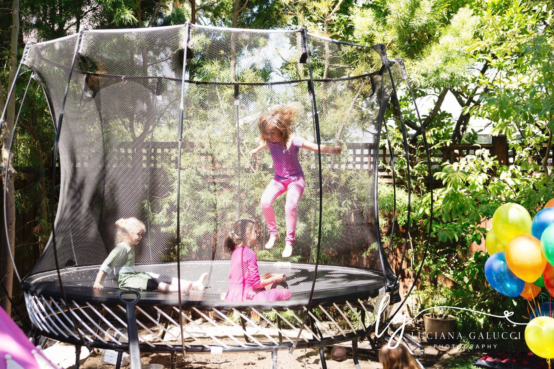 Birthday Party Portraits of children jumping in the backyard's trampoline in Raleigh NC