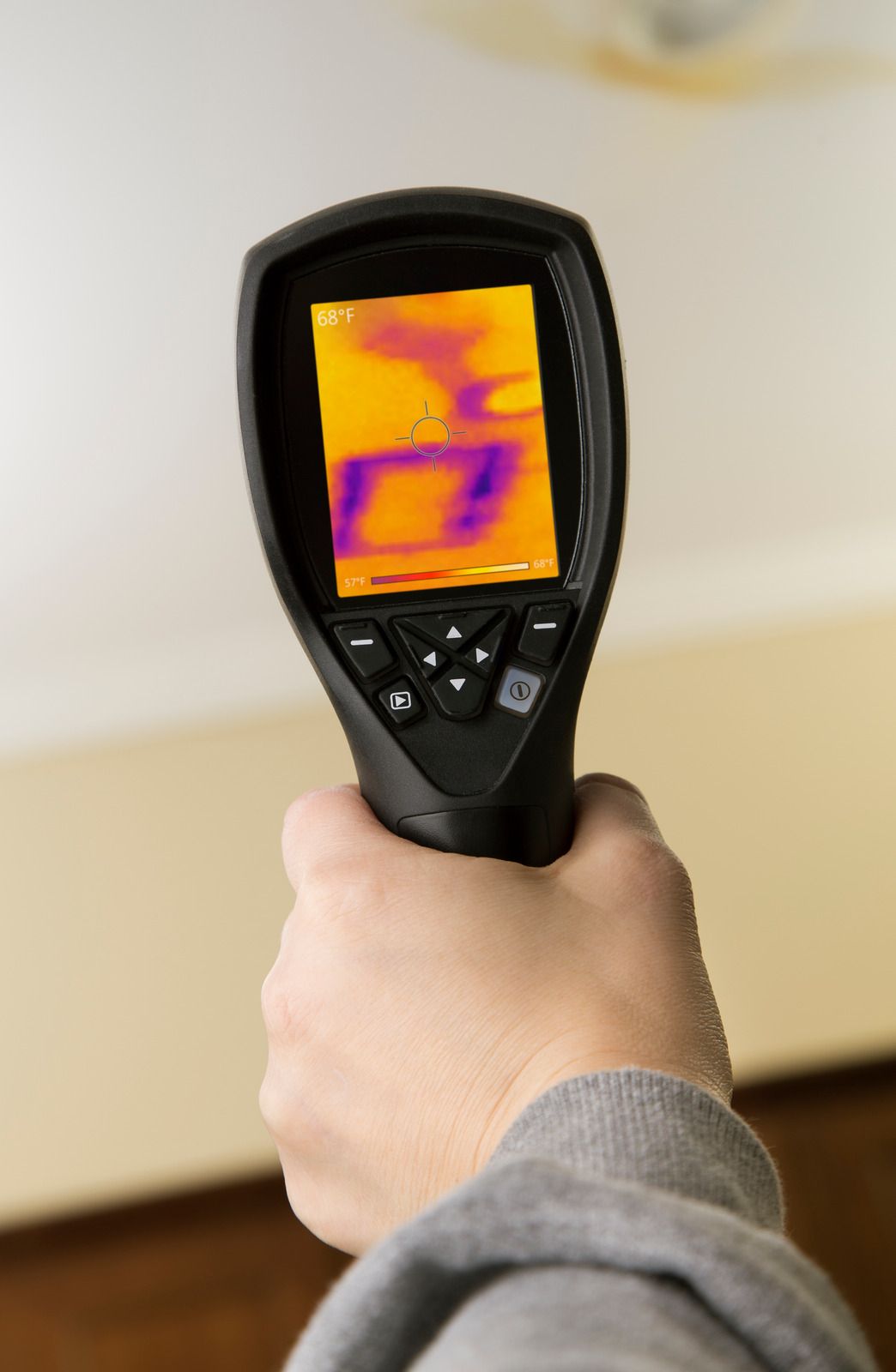 A person is holding a thermal camera in their hand.