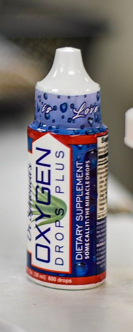 A bottle of oxygen drops plus dietary supplement is sitting on a table.