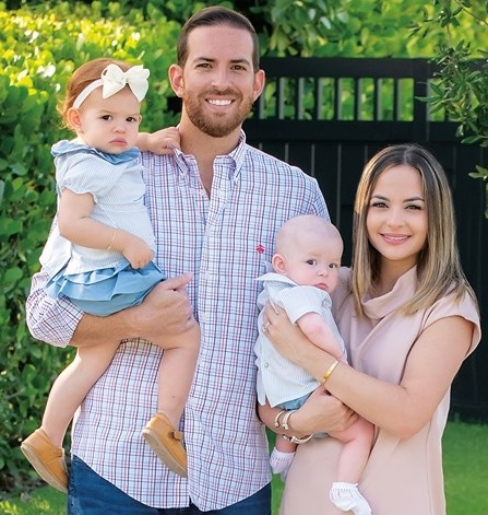 A man and woman are holding two babies in their arms.