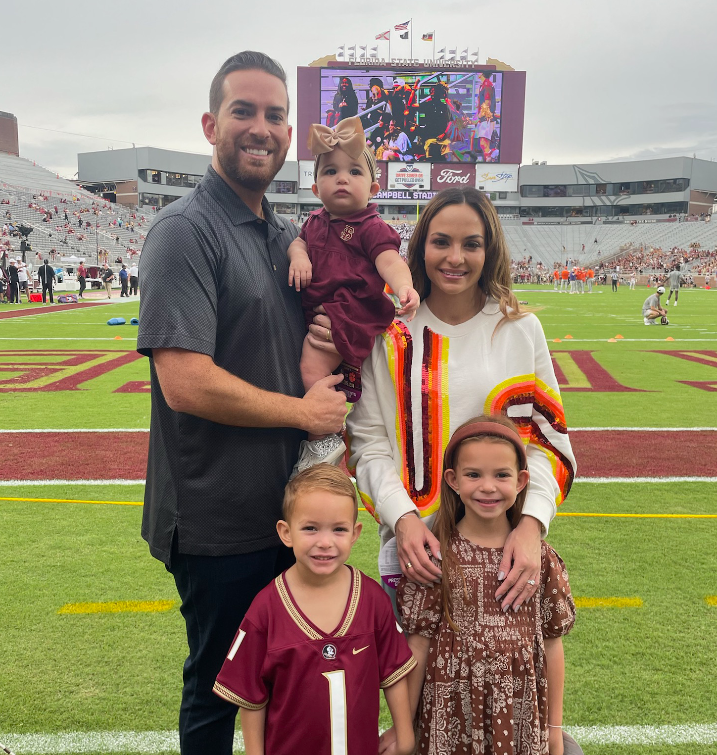 A family is posing for a picture on a football field.