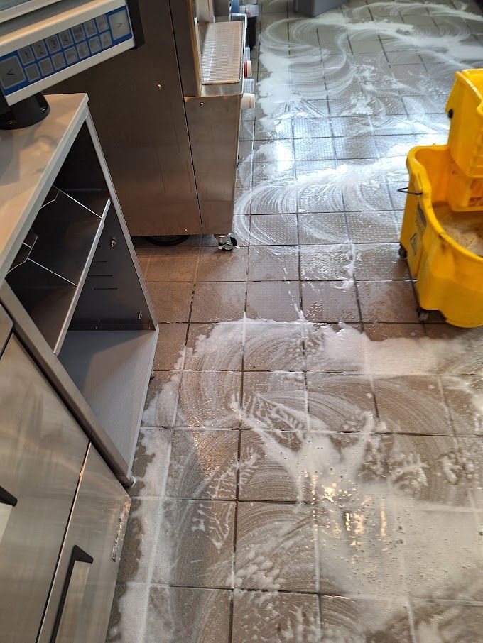 A person is spraying a couch with a spray bottle.