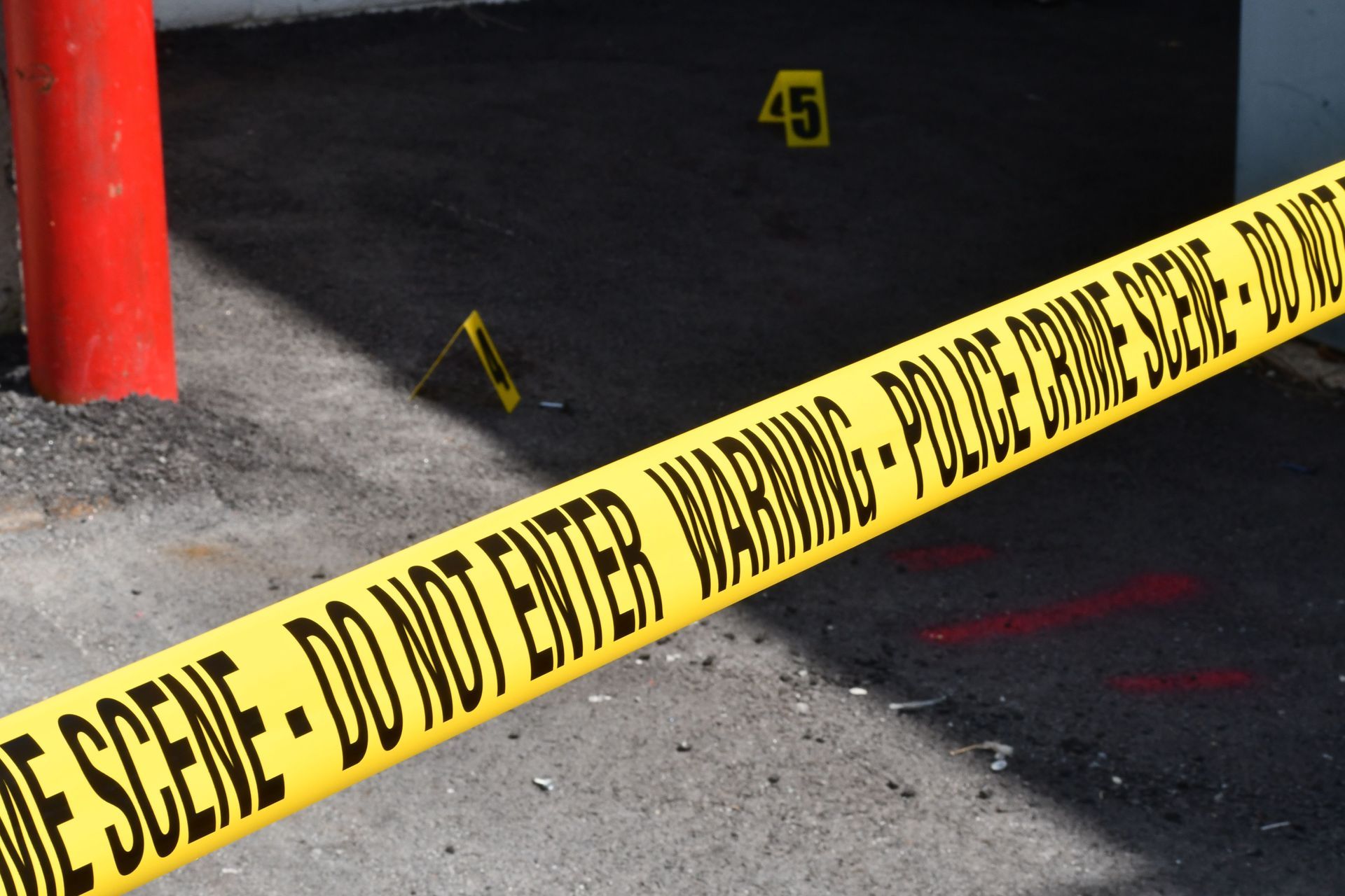 A man in a protective suit is standing in front of a caution tape.