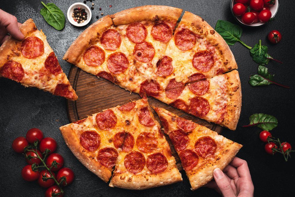 Picking Slice of Pepperoni Pizza — Port Townsend, WA — Waterfront Pizza Inc.