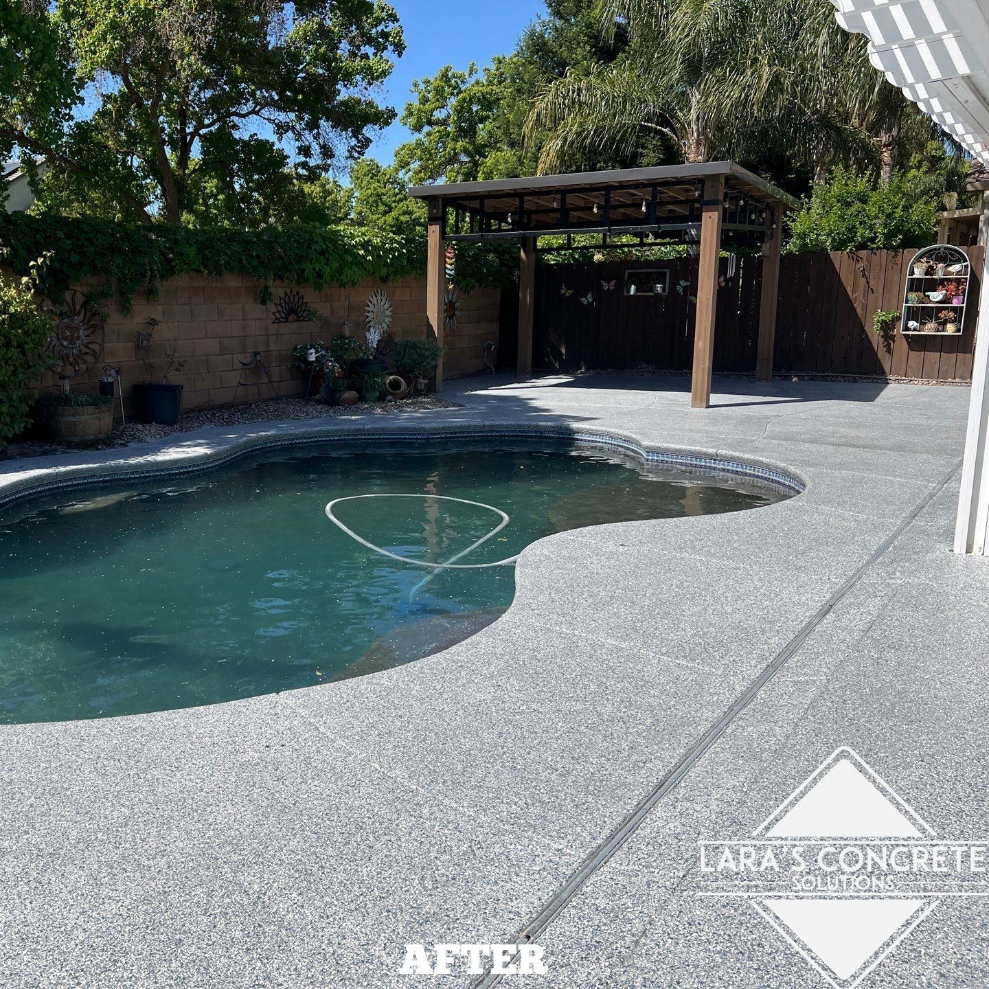 Backyard pool concrete coated deck with pool under a wooden pergola