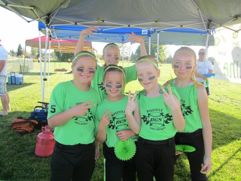 Four kids in neon green shirts posing under a canopy at an outdoor event