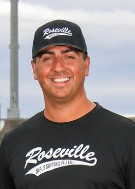 Man in a black Roseville shirt and cap smiling outdoors under a cloudy sky