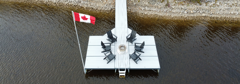 An aerial view of a slick aluminum pipe dock featuring a modern fire pit and Adirondack chairs placed at the end