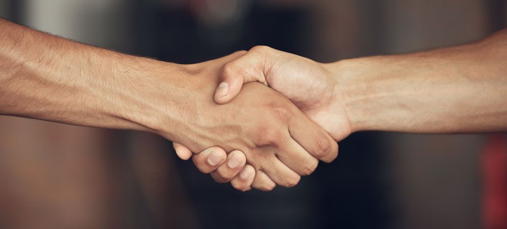 Competitive Compensation An image of two people shaking hands