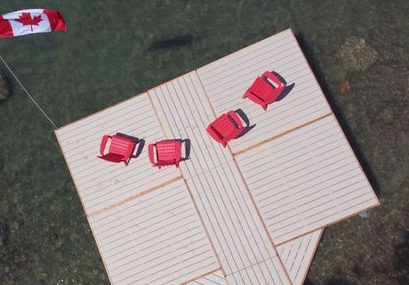 Docks Unlimited - Our Process Aerial view of a aluminum dock featuring bright red chairs and Canadian flag