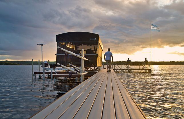 Docks Unlimited - Shorestation - Lift Accessories An image of a person walking a dock towards a canopy lift