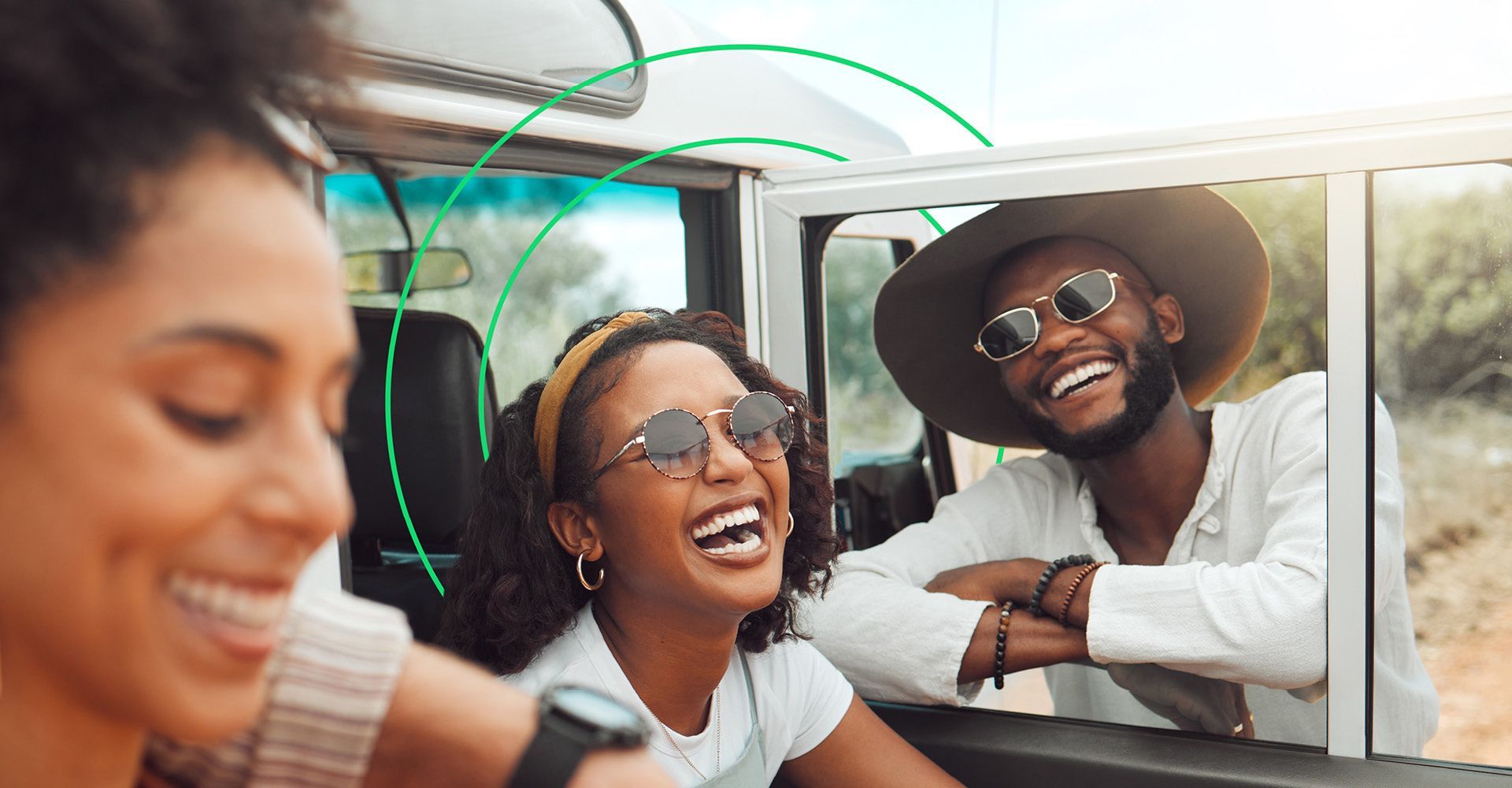 Group of people laughing while standing near an SUV