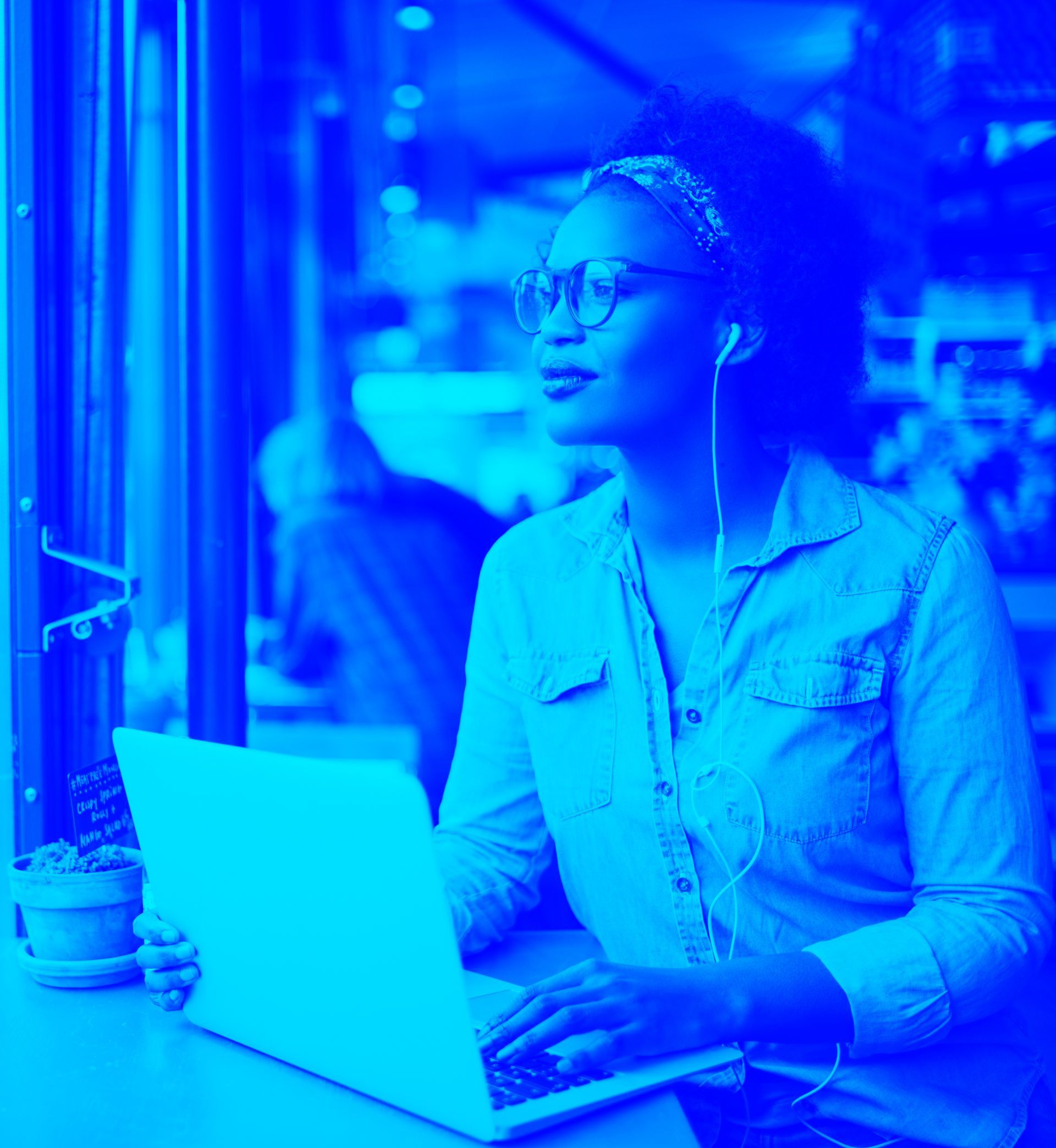 A woman is sitting at a table using a laptop computer.