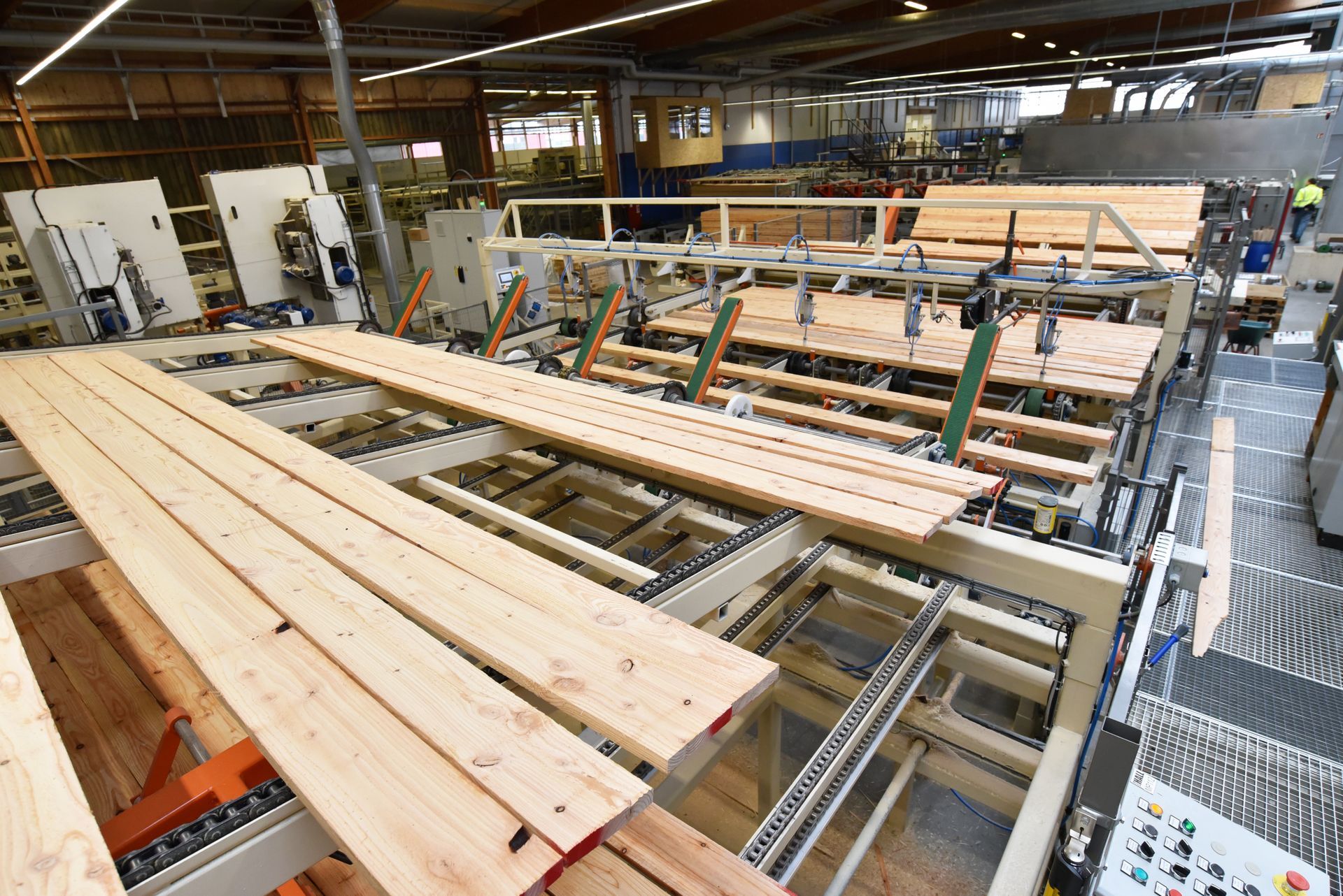Wood planks moving on an automated factory conveyor in a timber processing plant