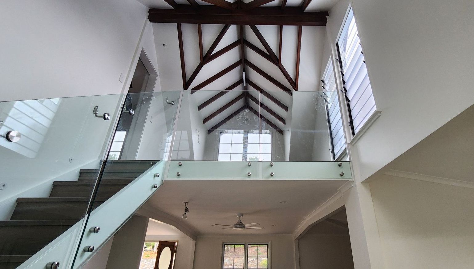A Building With Stairs and a Window With Shutters on It — Advancetech Glass & Glazing in Wulguru, QLD