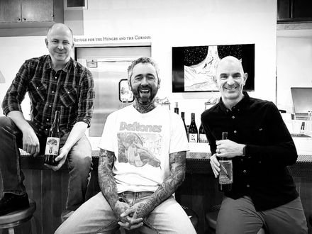 Matt Reese, Orion Stang, and Keith Robinson holding drinks in a casual gathering.