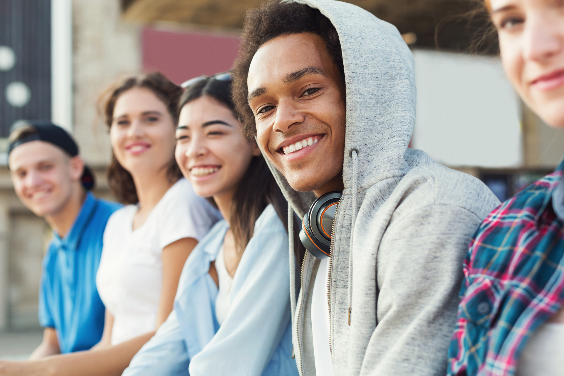 a group of young people are sitting next to each other and smiling .