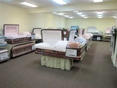 Hospital room with several empty beds under bright fluorescent lights