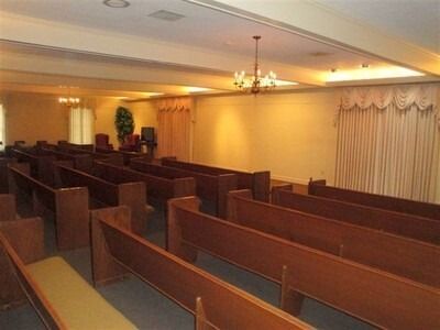Empty church sanctuary with wooden pews and warm ceiling lights