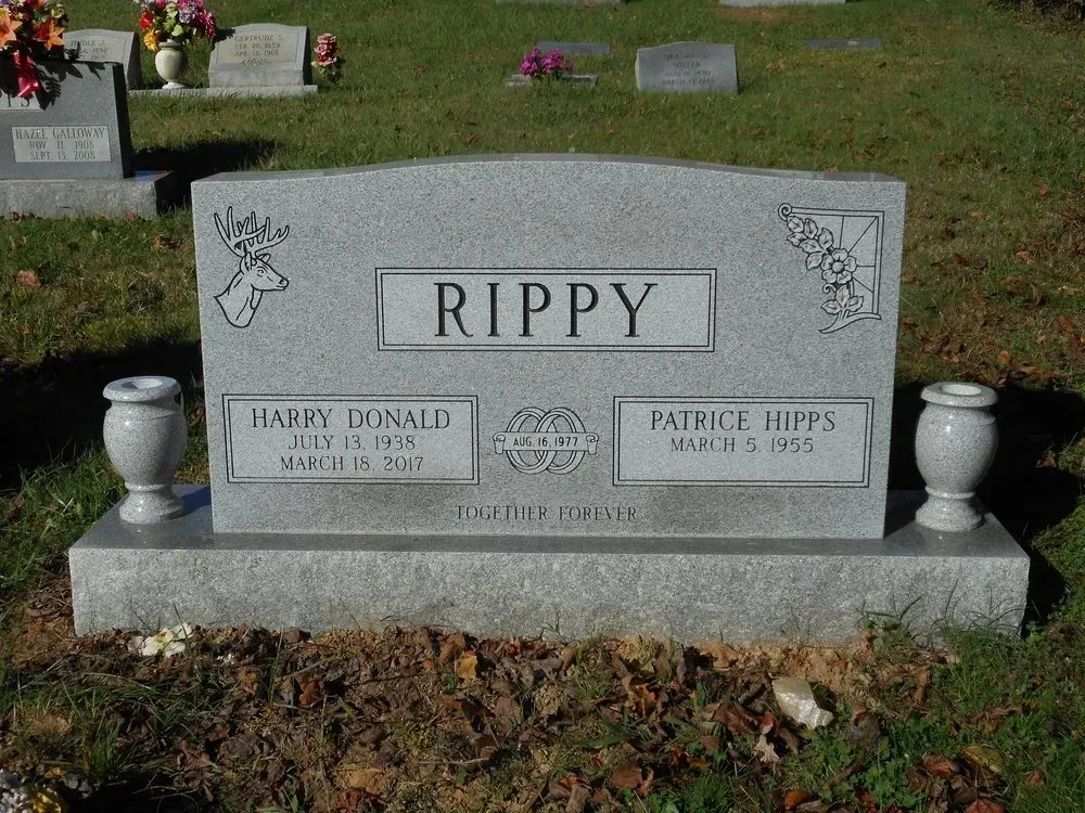 Gray Rippy gravestone in a cemetery, with small angel carvings and two name plaques.