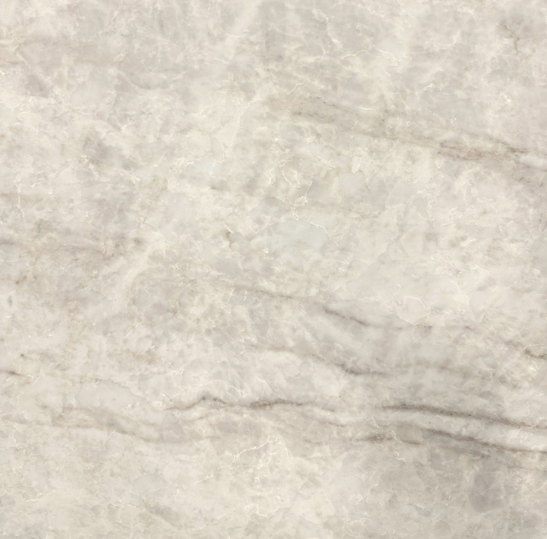 A surface with a light beige marble pattern, featuring soft, cloudy white textures and subtle grey veining.