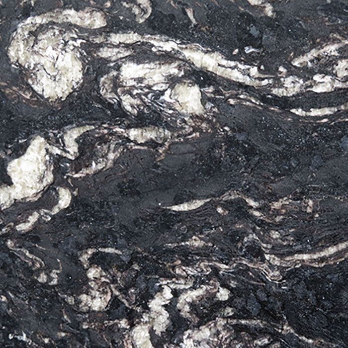 A close-up of a polished stone surface featuring swirling patterns of black, dark gray, and cream-colored veins.