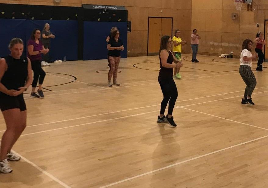 People exercising in a gymnasium during a group fitness class