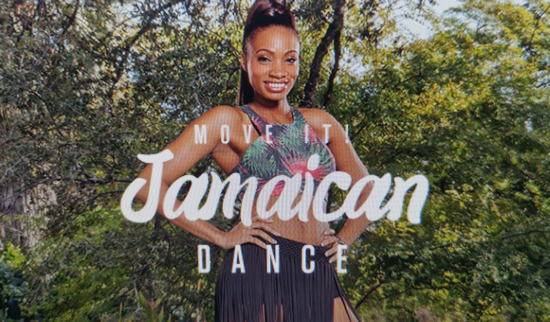 Woman smiling before greenery with “Jamaican Dance” text overlay