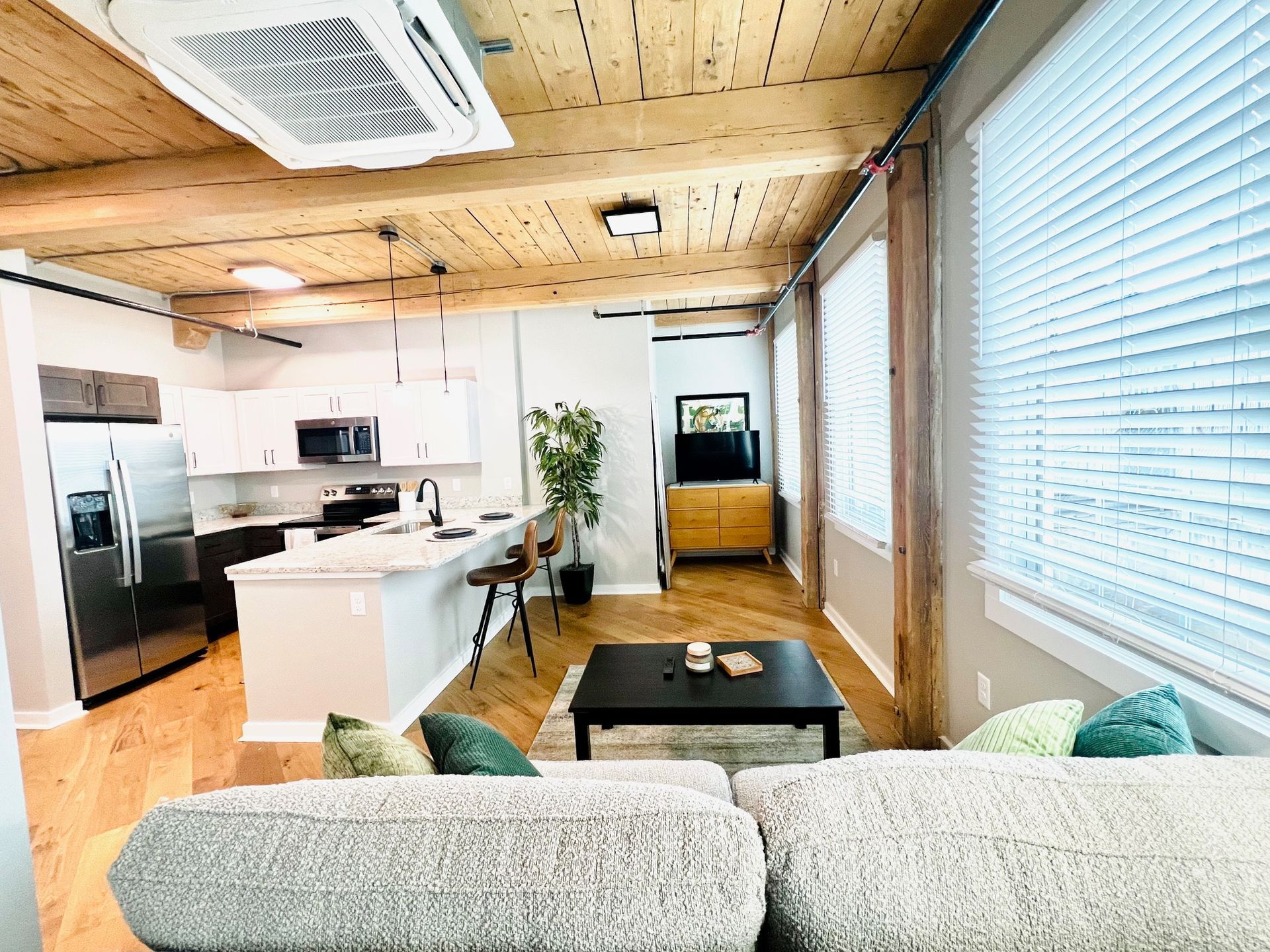 An open, light-filled living space with hardwood floors at The Reeds