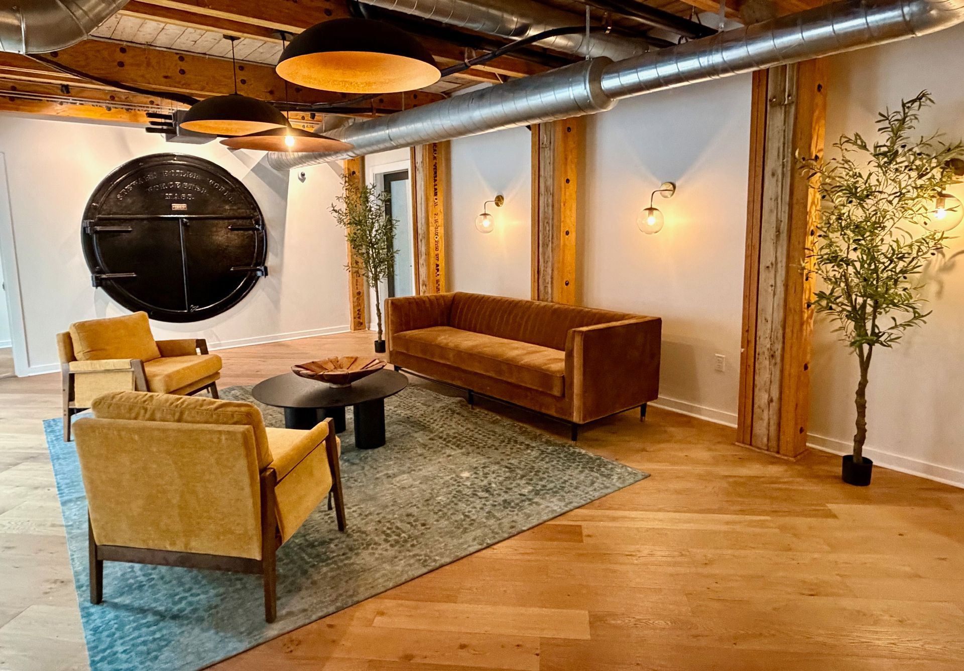 The resident lounge at The Reeds, featuring the building's original cast-iron factory door and exposed timber posts