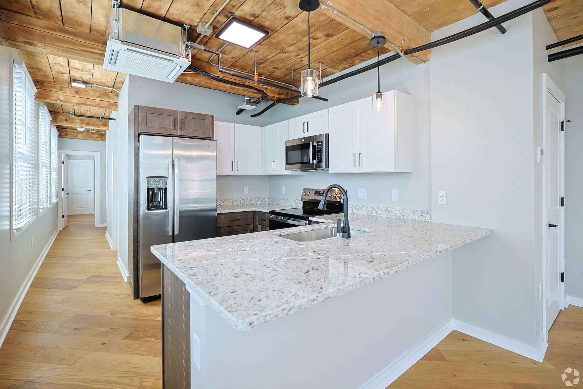 A renovated kitchen at The Reeds with granite counters and stainless appliances over hardwood floors