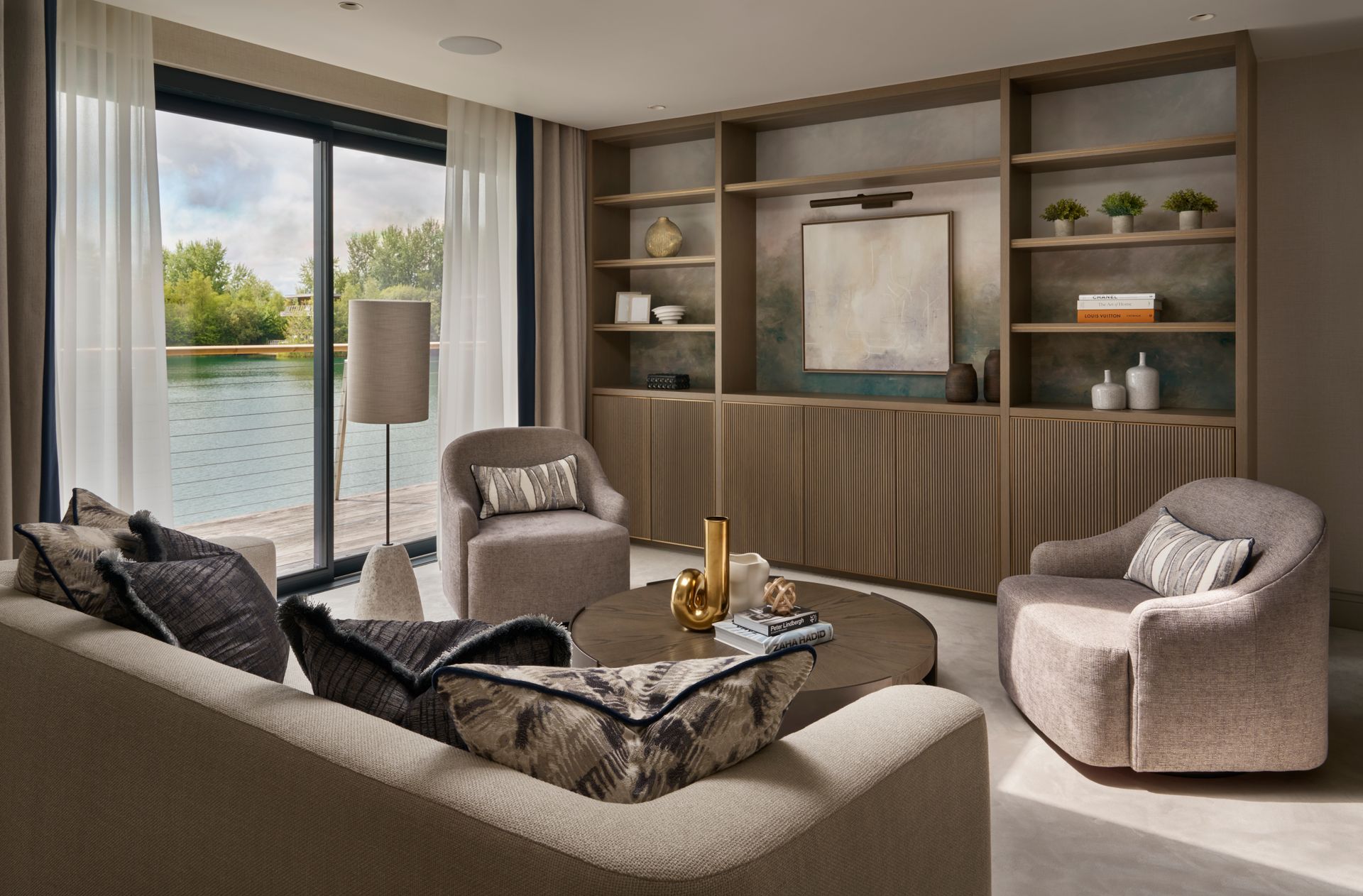 Living room with lake view, beige and gray decor, seating area, built-in shelves, and large window.