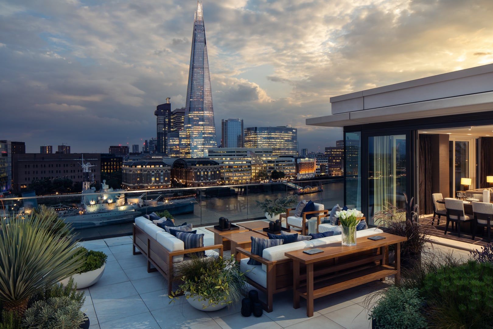 Rooftop patio overlooking London skyline at dusk with the Shard visible.