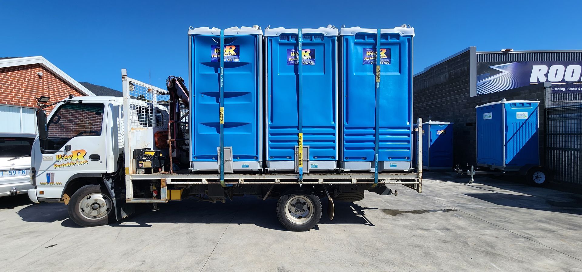 Blue cargo truck with tall blue containers parked in an industrial yard — Wee R Pumping In Glenorchy, TAS