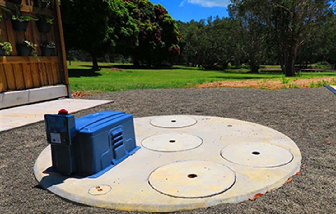 Blue utility generator on a circular concrete pad in a grassy park area — Wee R Pumping In Glenorchy, TAS