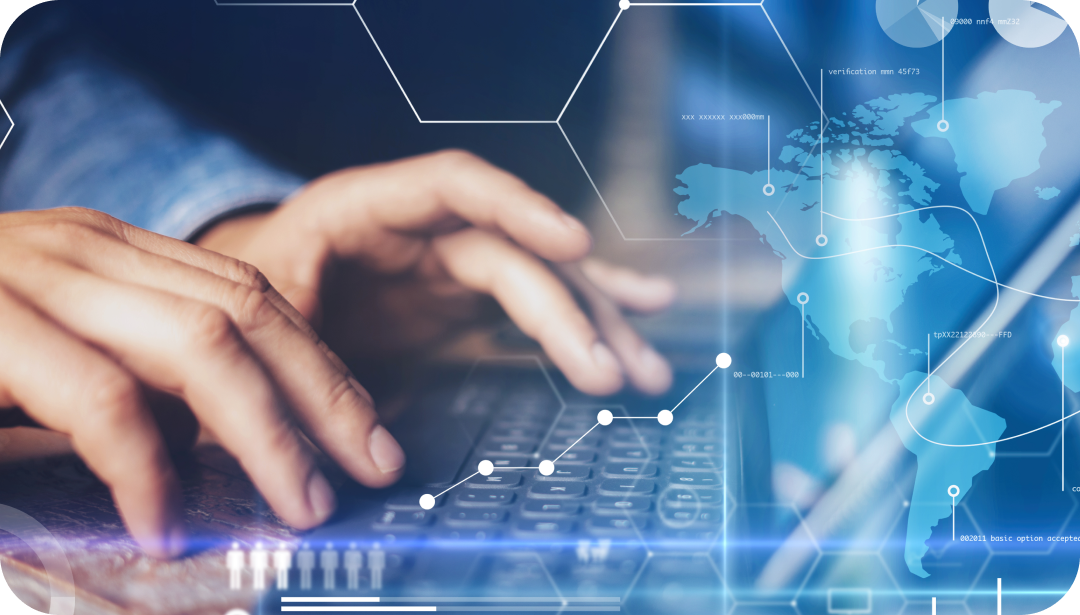 Hands typing on a keyboard with a glowing blue digital overlay including a world map and data visualization. Hands typing on a keyboard with a glowing blue digital overlay including a world map and data visualization.