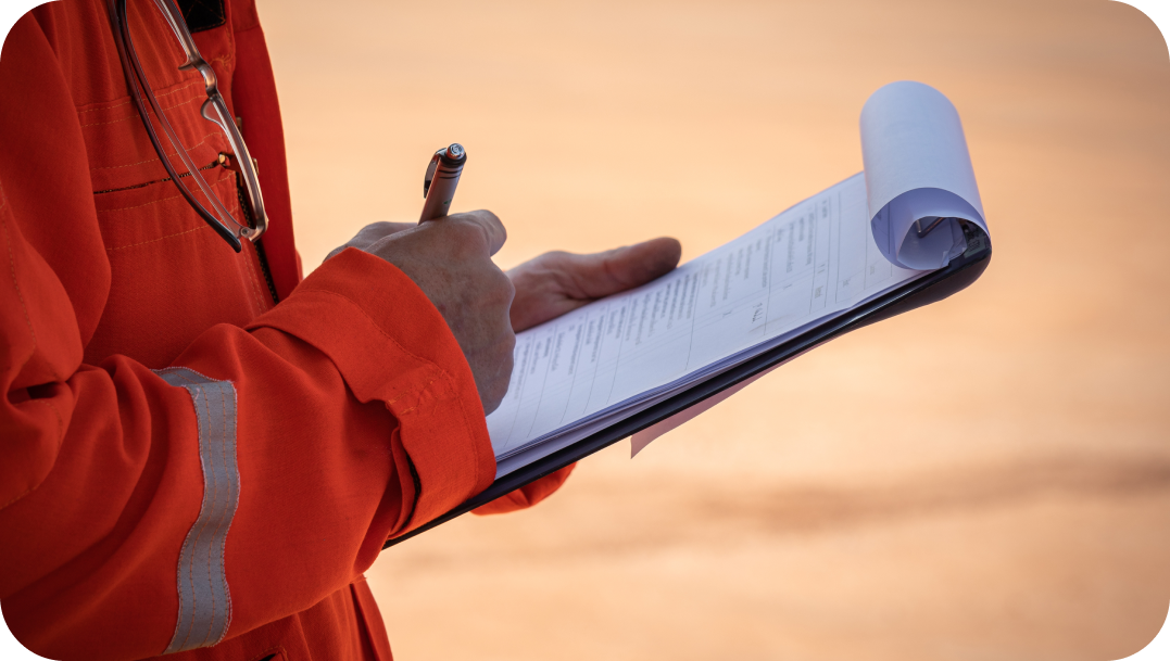 Person in orange workwear writing on a clipboard outdoors, likely taking notes or doing an inspection. Person in orange workwear writing on a clipboard outdoors, likely taking notes or doing an inspection.