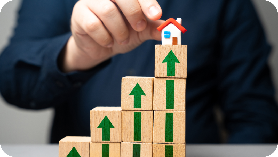 Hand placing a small house on a stack of blocks with upward arrows, symbolizing growth and real estate. Hand placing a small house on a stack of blocks with upward arrows, symbolizing growth and real estate.