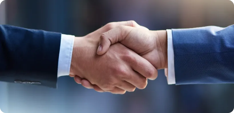 Two people shaking hands in a business deal, close up, showing agreement.