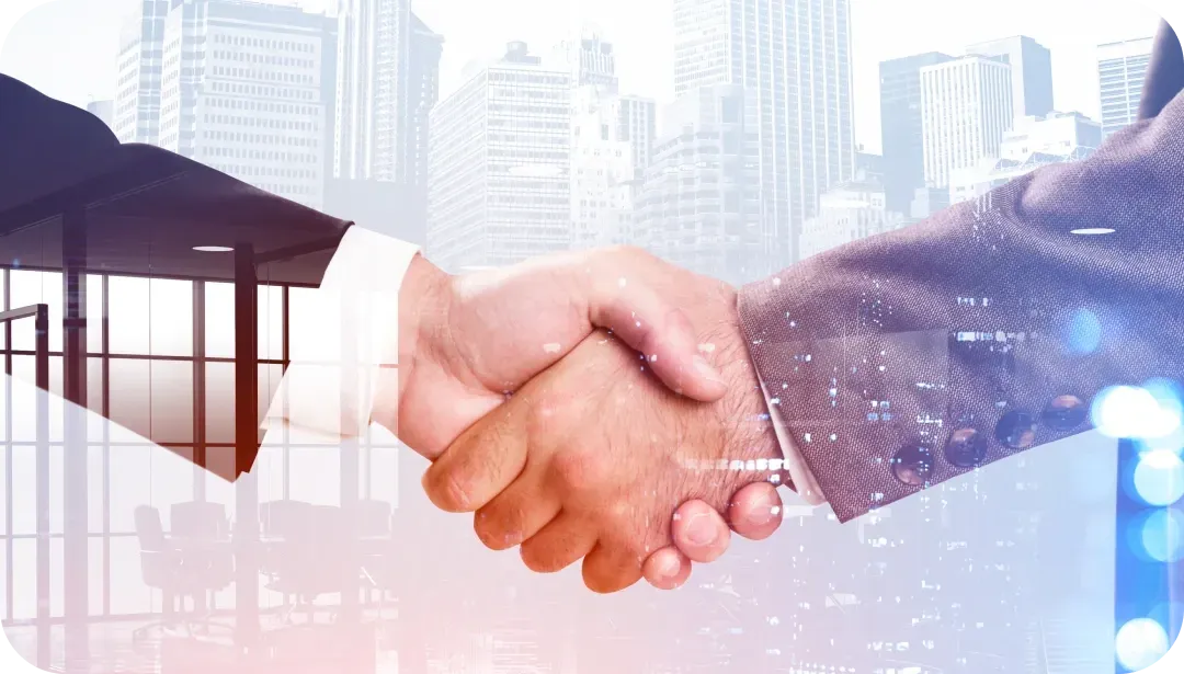 Two people in business suits shaking hands, a city and office space overlayed in the background. Two people in business suits shaking hands, a city and office space overlayed in the background.