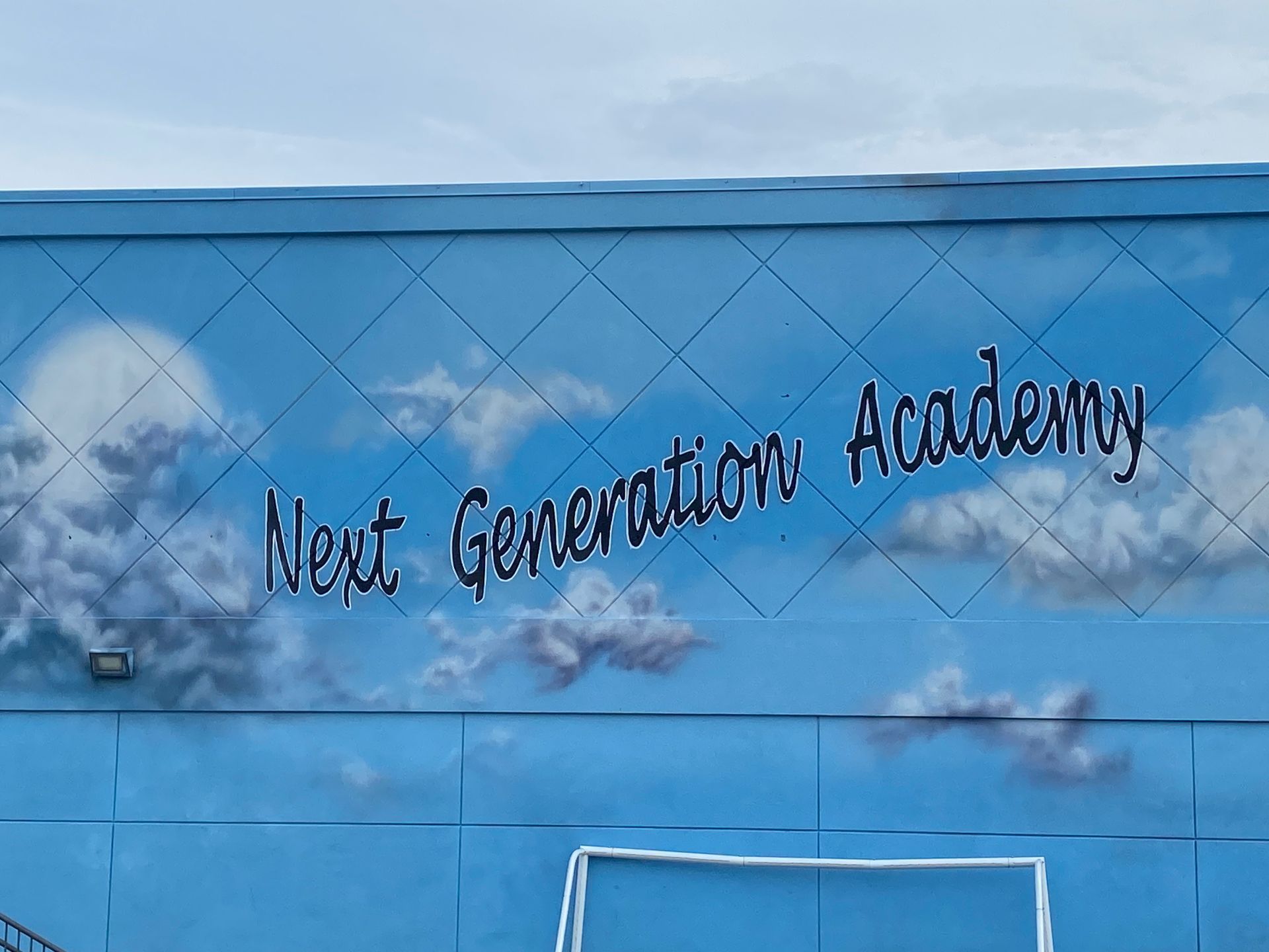 A blue wall with the words next generation academy painted on it