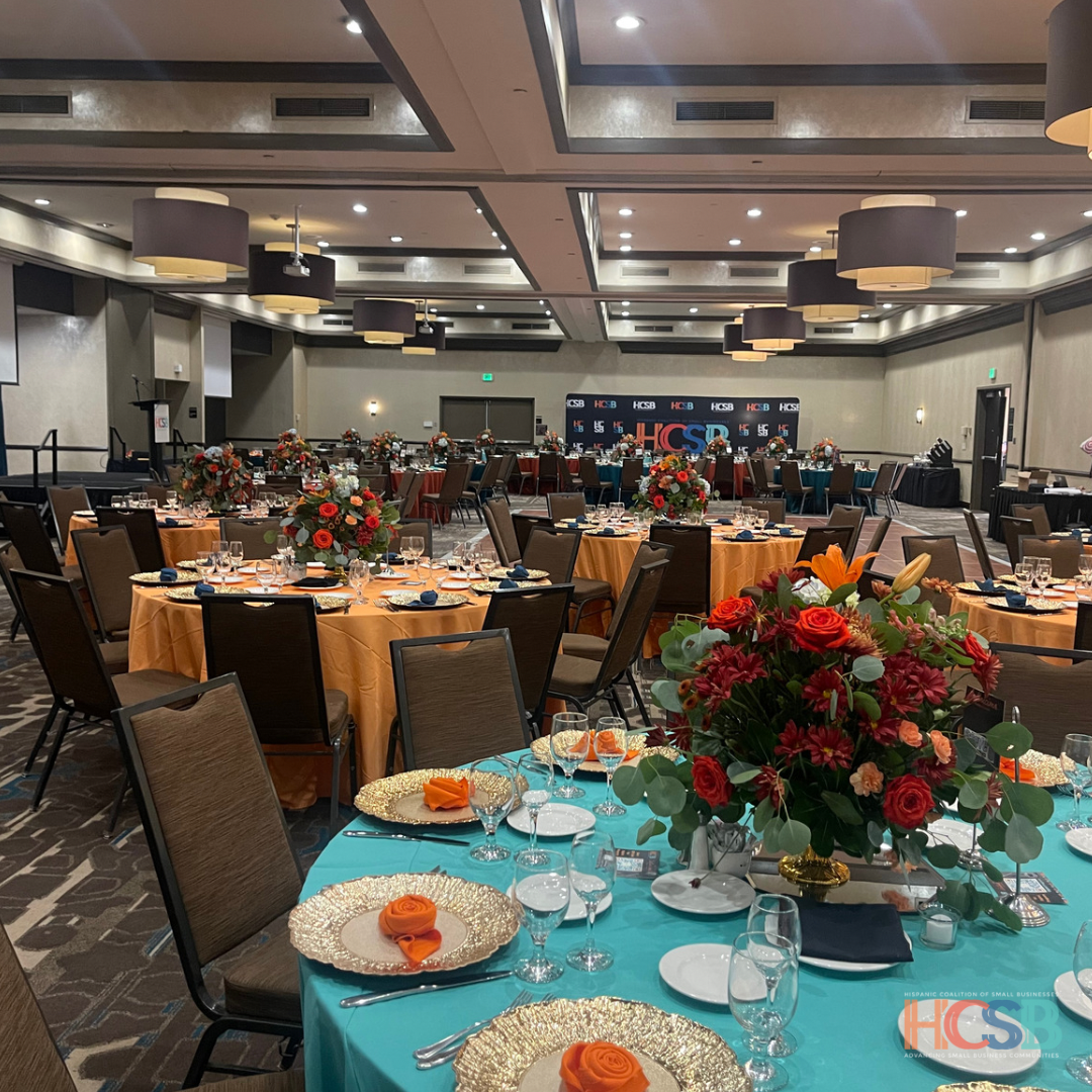 A large room filled with tables and chairs and a sign that says hcs
