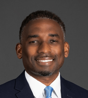 A man in a suit and tie is smiling for the camera.