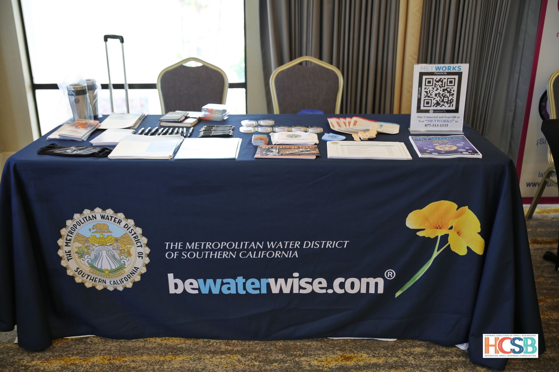 A table with a blue table cloth that says bewaterwise.com